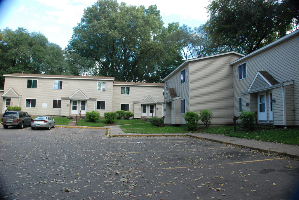 an empty parking lot in front of a row of houses
